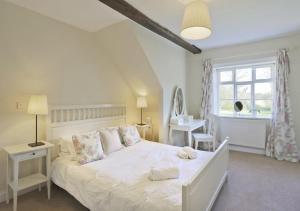 a bedroom with a white bed and a window at Park Farm House in Wangford