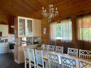 cocina con mesa, sillas y lámpara de araña en Villa Maaria, LaatuLomat, en Juva