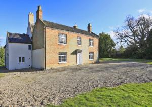 an old brick house with a gravel driveway at Park Farm House in Wangford