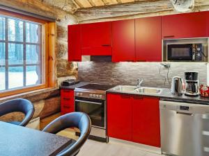 een keuken met rode kasten en een wastafel bij Holiday Home Kitkankuru a by Interhome in Kuusamo