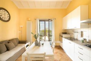 een keuken en een woonkamer met een bank en een tafel bij Sweet Home Contignano in Contignano
