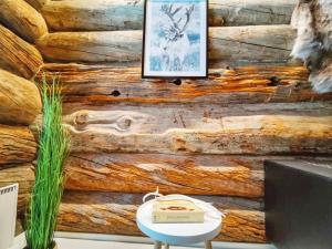 Habitación con pared de madera, mesa y TV. en Holiday Home Kitkankuru b by Interhome, en Kuusamo