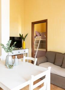 een woonkamer met een tafel, een bank en een spiegel bij Sweet Home Contignano in Contignano