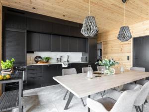 a kitchen with a large wooden table and chairs at Holiday Home Saunamäki resort villa n in Särkisalo