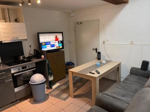 sala de estar con sofá, mesa y TV en Apartment Breite Straße zwischen Köln und Aachen, en Kerpen