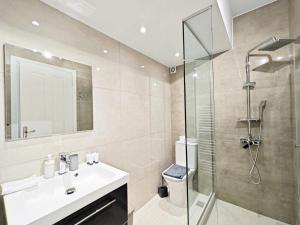 une salle de bain avec un lavabo et une douche en verre dans l'établissement Omorfokklisias by Verde Apartments, à Athènes 62 autres photos