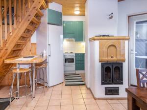 a kitchen with green cabinets and a staircase at Holiday Home Tahkon alppitalo 4 as- 3 by Interhome in Tahkovuori