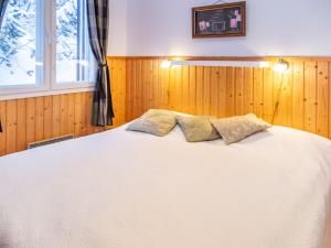 a bedroom with a large white bed with a window at Holiday Home Tahkon alppitalo 4 as- 3 by Interhome in Tahkovuori