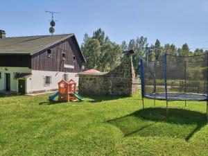 a yard with a swing set and a barn at Holiday Home Hodkovice by Interhome in Adršpach