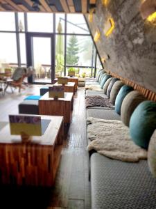 a row of couches with pillows and tables in a room at Pino Nature Hotel, BW Premier Collection in Sarajevo