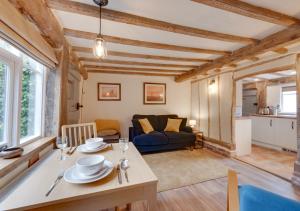 a living room with a table and a couch at Perry Acres Cottage in Saxtead