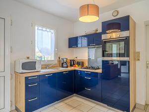 サン・フィリベールにあるHoliday Home L'Armoricaine by Interhomeのキッチン(青いキャビネット、電子レンジ付)
