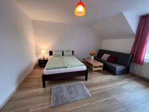 una piccola camera da letto con un letto e un divano di Agroturystyka Porbady a Porbady