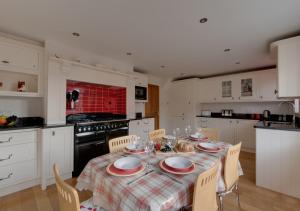 una cocina con mesa y sillas con mantel. en Poppy Corner, en Southwold