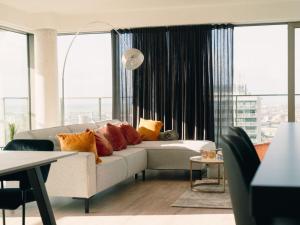 sala de estar con sofá blanco y ventanas grandes en Apartment SKY Tower One by Interhome, en Ostende