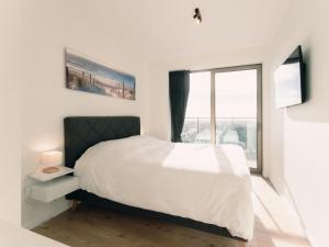 1 dormitorio con cama y ventana grande en Apartment SKY Tower One by Interhome, en Ostende