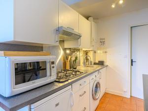 a kitchen with a microwave and a stove at Apartment Le Quai by Interhome in La Trinité-sur-Mer