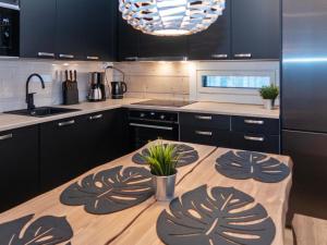 eine Küche mit schwarzen Schränken und einem Holztisch in der Unterkunft Holiday Home Mäkitie 2 by Interhome in Aikkila
