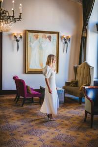 a woman in a white dress standing in front of a painting at Esplanade Zagreb Hotel in Zagreb