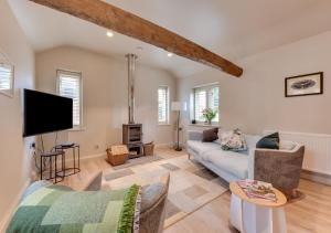 uma sala de estar com um sofá e uma televisão em Rose Farm Barn em Middleton