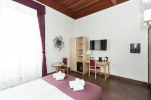 1 dormitorio con cama, escritorio y mesa en SuitInn19, en Roma