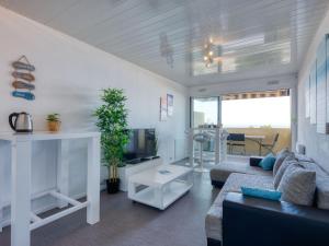 a living room with a couch and a tv at Apartment Les Océanides-19 by Interhome in Lacanau-Océan