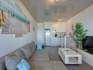 a living room with a couch and a kitchen at Apartment Les Océanides-19 by Interhome in Lacanau-Océan