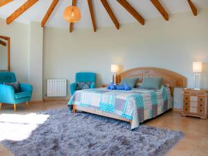 a bedroom with a bed and two blue chairs at Holiday Home Mazo by Interhome in Benissa