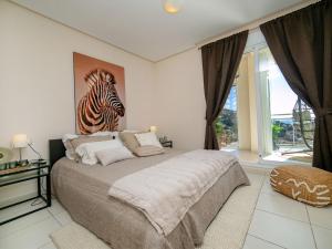 a bedroom with a bed with a zebra picture on the wall at Apartment Jardines de Altea Hills-4 by Interhome in Altea