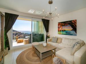 a living room with a white couch and a large window at Apartment Jardines de Altea Hills-4 by Interhome in Altea