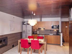 a kitchen with a wooden table and red chairs at Holiday Home Tahko spa junior suite orange a 10 by Interhome in Tahkovuori