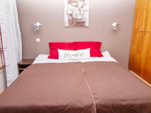 a bed with a red and white pillow on it at Holiday Home Tahko spa junior suite orange a 10 by Interhome in Tahkovuori
