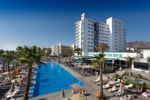 a pool in a resort with palm trees and buildings at Hotel Riu Costa del Sol - All Inclusive in Torremolinos