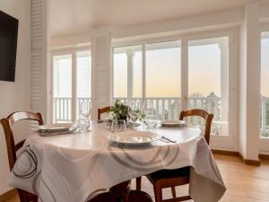 a dining room table with a white table cloth on it at Apartment Le Parc Cordier-6 by Interhome in Trouville-sur-Mer