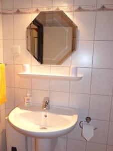 a bathroom with a white sink and a mirror at Ferienwohnung Conny am Südstrand Familie Bach in Burgtiefe auf Fehmarn 