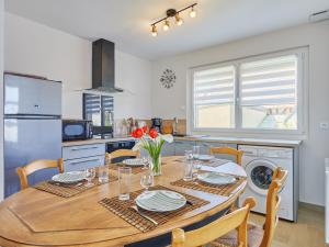 a kitchen with a wooden table with chairs and a dining room at Holiday Home Janomaine by Interhome in Cabourg