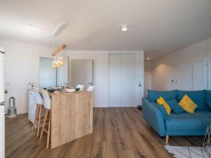 ein Wohnzimmer mit einem blauen Sofa und einem Tisch in der Unterkunft Apartment Le Rooftop by Interhome in Lacanau-Océan + 27 Fotos