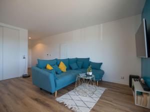 ein blaues Sofa im Wohnzimmer mit einem Tisch in der Unterkunft Apartment Le Rooftop by Interhome in Lacanau-Océan