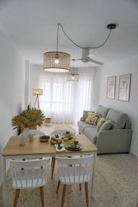 sala de estar con mesa, sillas y sofá en Apartamento El Sol Naciente, en La Herradura