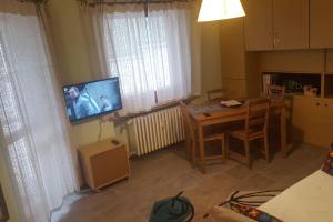uma cozinha com uma mesa e uma televisão num quarto em Bardonecchia, monolocale, ottima posizione. em Bardonecchia