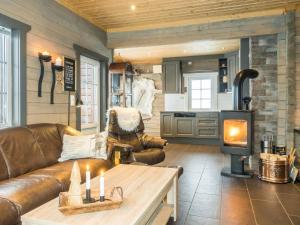 uma sala de estar com um sofá de couro e um fogão a lenha em Holiday Home Saanaloma by Interhome em Kilpisjärvi
