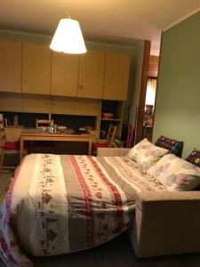 um quarto com uma cama com um cobertor em Bardonecchia, monolocale, ottima posizione. em Bardonecchia