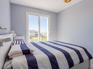 - une chambre avec un lit rayé et une fenêtre dans l'établissement Holiday Home Paradis des Dunes by Interhome, à Bretteville-sur-Ay