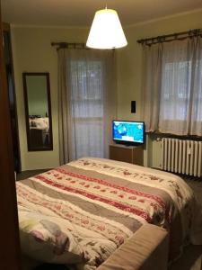 um quarto com uma cama e uma televisão de ecrã plano em Bardonecchia, monolocale, ottima posizione. em Bardonecchia