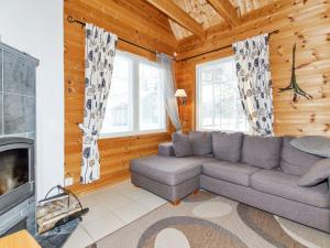 ein Wohnzimmer mit Couch und Kamin in der Unterkunft Holiday Home Saunaharju 7 by Interhome in Hattusaari