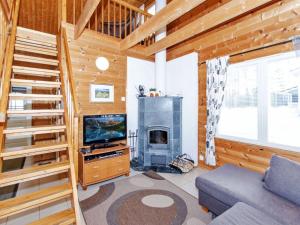 ein Wohnzimmer mit Kamin und Fernseher in der Unterkunft Holiday Home Saunaharju 7 by Interhome in Hattusaari