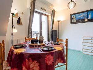 una mesa de comedor con un mantel rojo. en Studio Cabourg Plage-20 by Interhome, en Cabourg