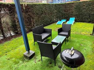 een groep stoelen en een grill in een tuin bij Super appart 50m² avec jardin V2 in Villeneuve d'Ascq