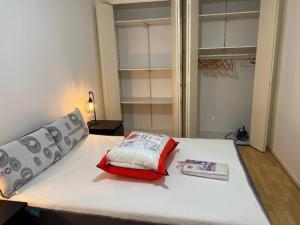 - une chambre avec un lit doté d'un oreiller rouge et blanc dans l'établissement Super appart 50m² avec jardin V2, à Villeneuve d'Ascq