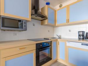 cocina con armarios de madera y horno con fogones en Apartment Arc en Ciel Vue Mer by Interhome, en Les Bains